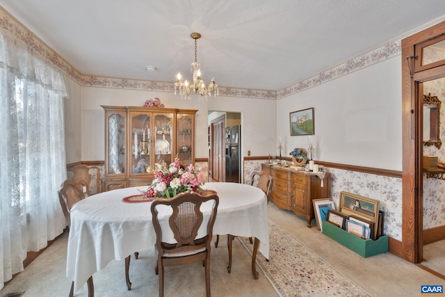 carpeted dining space with an inviting chandelier