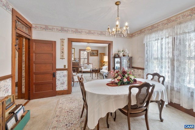 dining room featuring light colored carpet and a notable chandelier