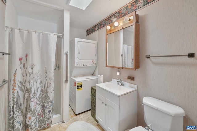 bathroom featuring vanity, toilet, stacked washer and dryer, and walk in shower