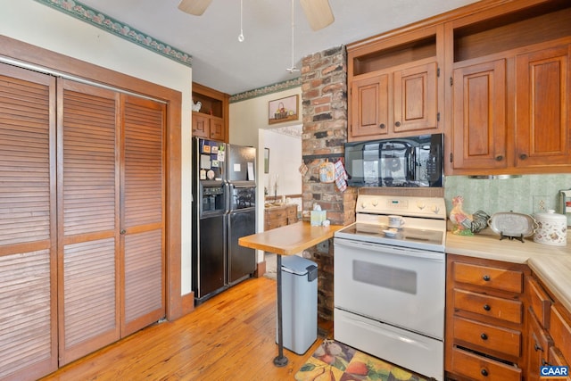 kitchen with black appliances, ceiling fan, light wood-type flooring, and backsplash