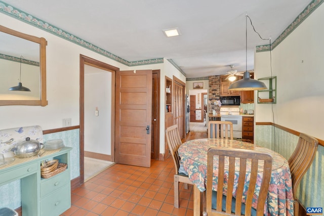 tiled dining space with ceiling fan