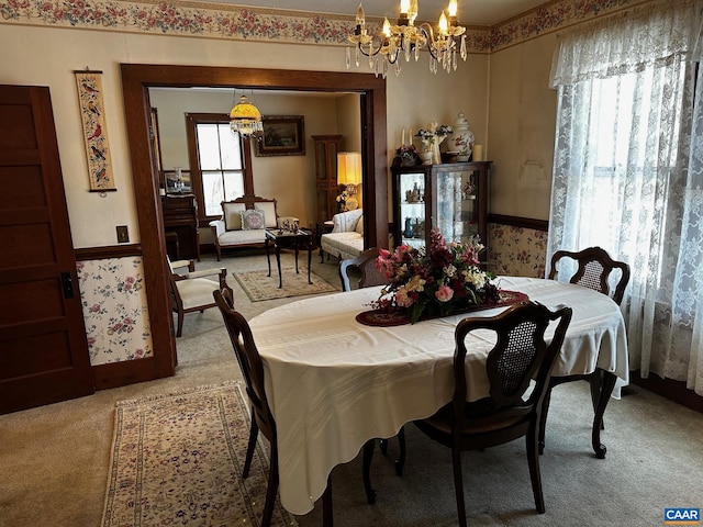 carpeted dining space featuring a notable chandelier