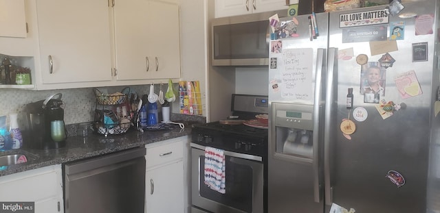 kitchen featuring white cabinets, dark stone countertops, appliances with stainless steel finishes, and tasteful backsplash