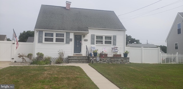 cape cod home featuring a front yard