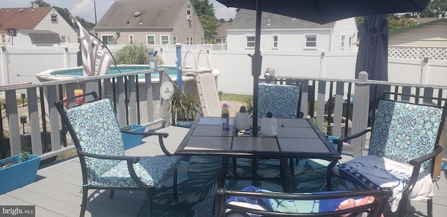 wooden balcony featuring pool water feature and a deck