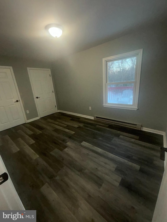 interior space featuring dark hardwood / wood-style floors and a baseboard heating unit