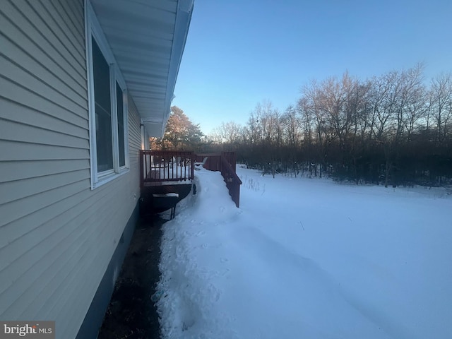 yard layered in snow featuring a wooden deck