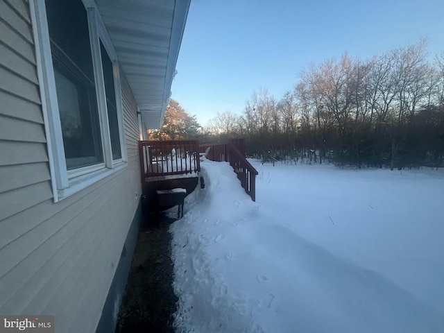 yard layered in snow with a deck