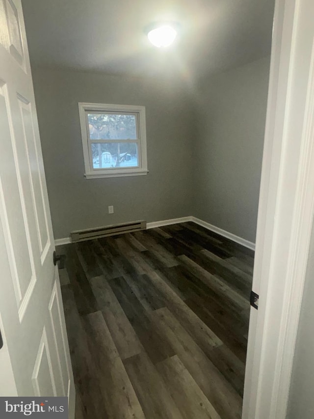 bonus room with dark wood-type flooring and a baseboard heating unit