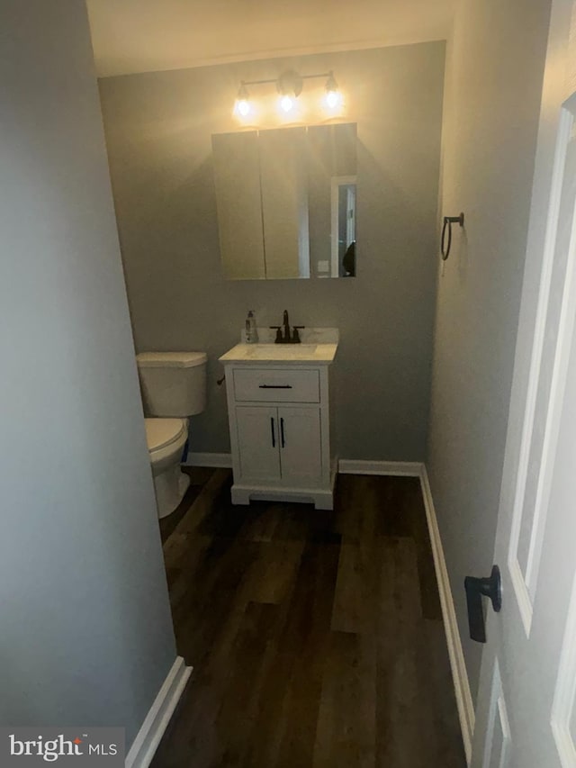 bathroom featuring hardwood / wood-style floors, vanity, and toilet