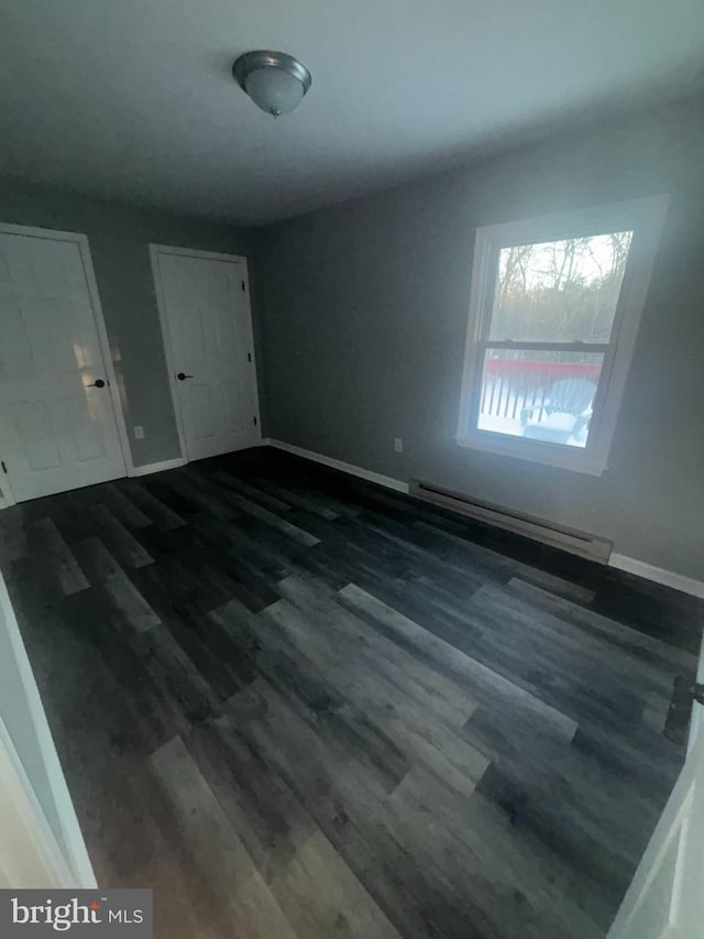 interior space featuring dark hardwood / wood-style flooring and a baseboard heating unit