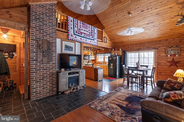 living room with wood ceiling, high vaulted ceiling, ceiling fan, and wood walls