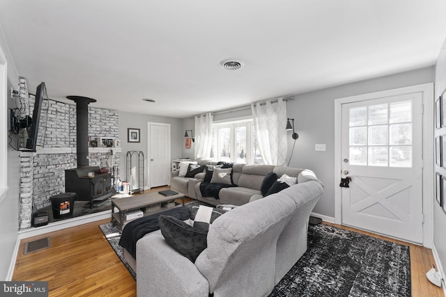 living room featuring wood-type flooring and a wood stove