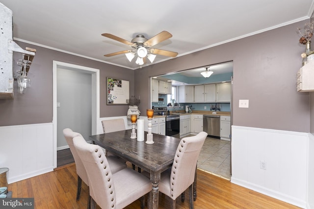 dining space with ceiling fan, light hardwood / wood-style floors, and ornamental molding