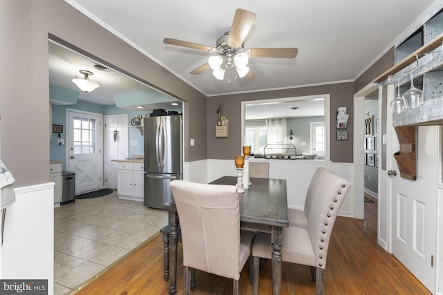 dining area featuring tile patterned floors, ceiling fan, and crown molding