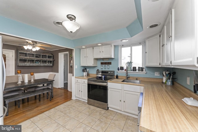 kitchen featuring ceiling fan, sink, white cabinets, stainless steel electric range, and light tile patterned floors