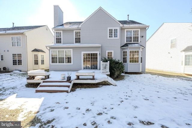 view of snow covered rear of property