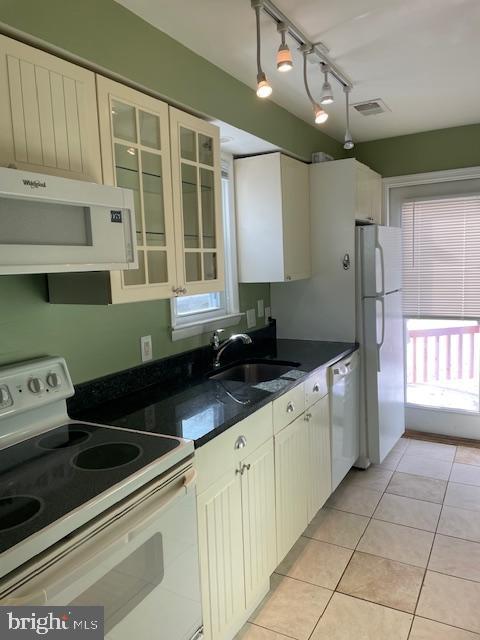 kitchen featuring light tile patterned floors, white appliances, plenty of natural light, and sink