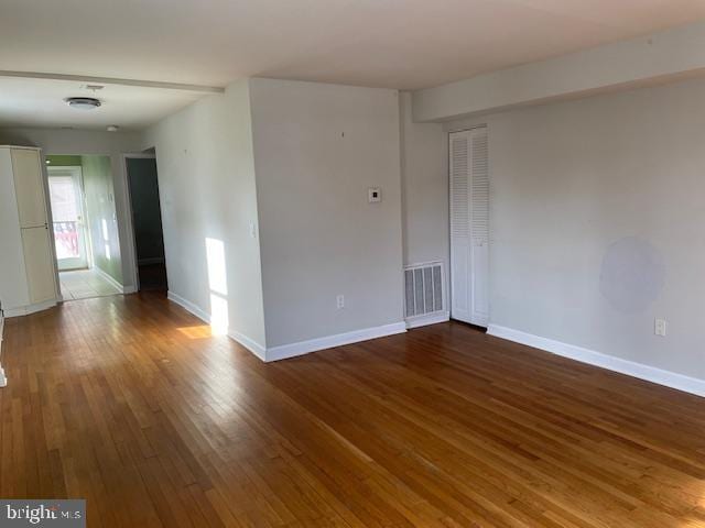 unfurnished room with dark hardwood / wood-style flooring