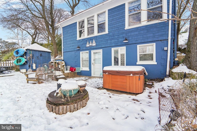 snow covered property featuring a hot tub