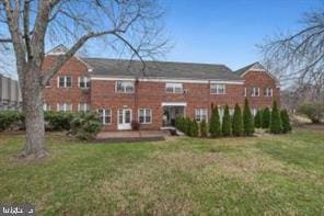 rear view of house featuring a lawn