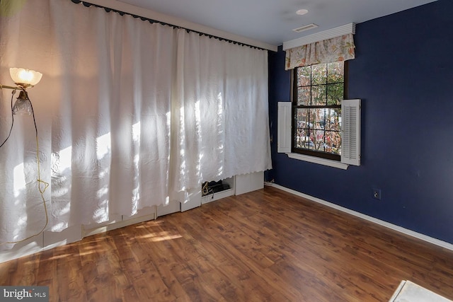 unfurnished room featuring crown molding and hardwood / wood-style floors