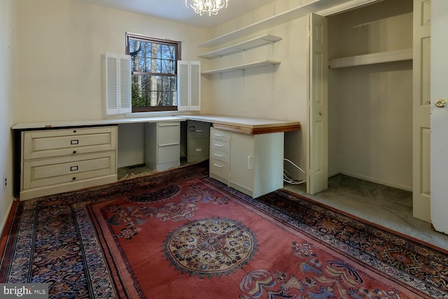 unfurnished office with built in desk and a chandelier