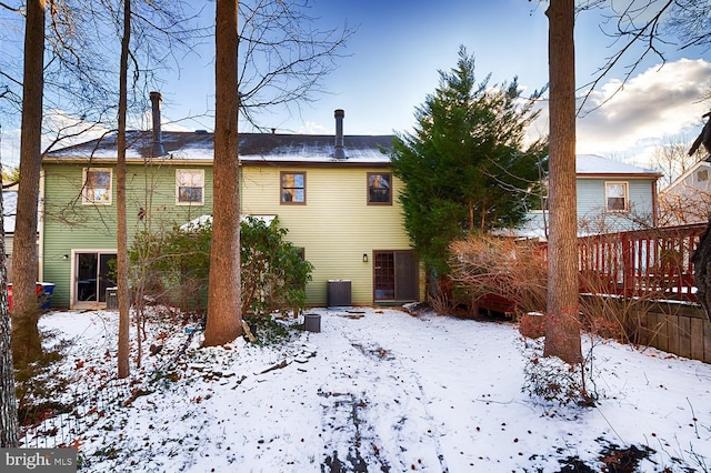 snow covered property with central AC