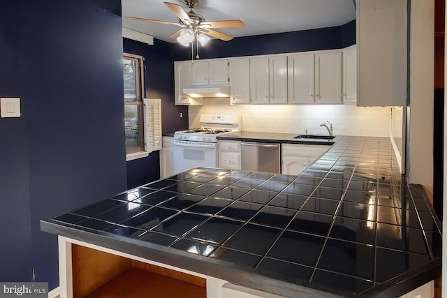 kitchen featuring dishwasher, sink, white cabinets, tile counters, and gas range gas stove