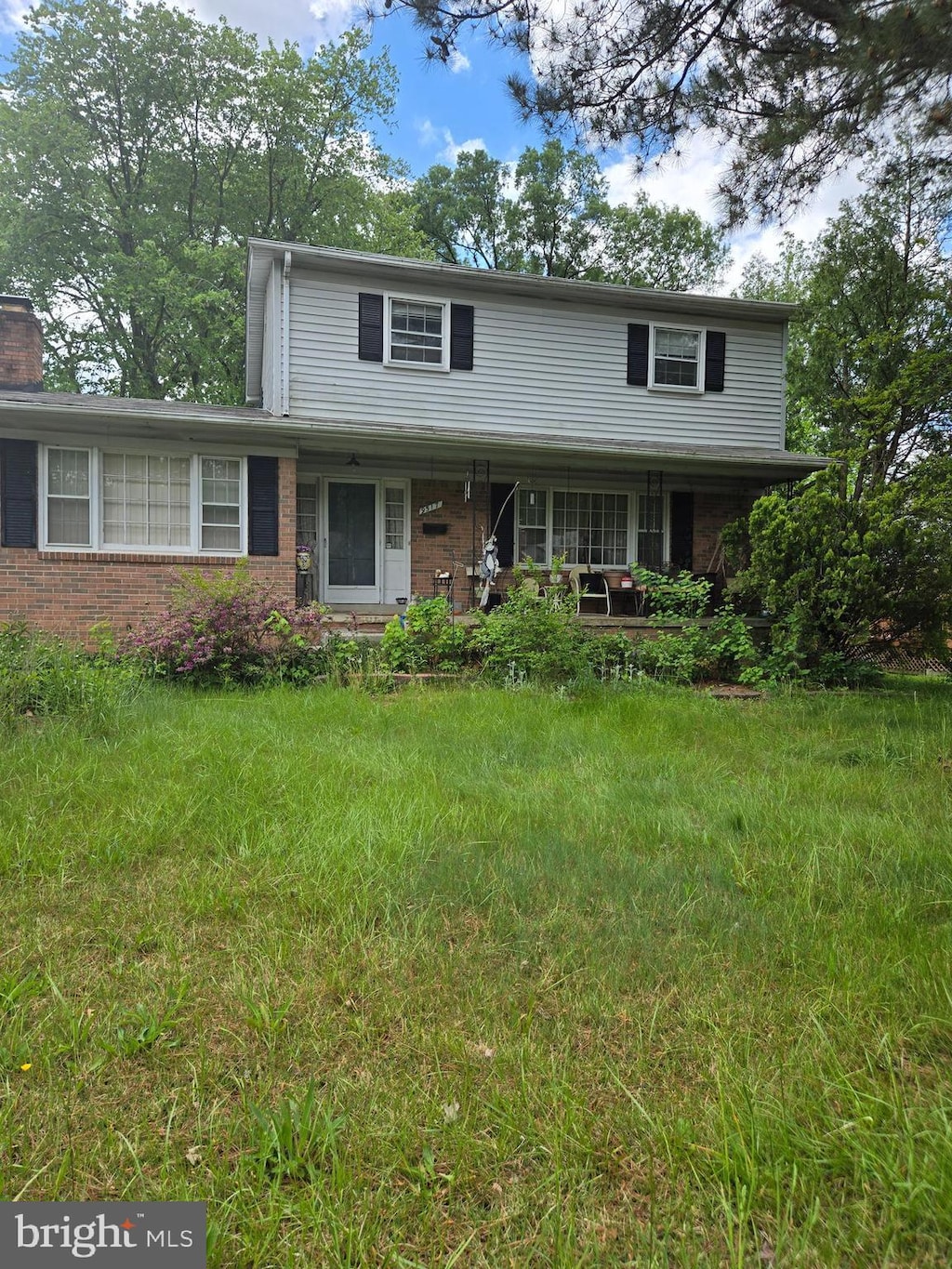 9517 Nordic Dr, Lanham, MD 20706 - traditional-style house with a porch, brick siding, and a chimney