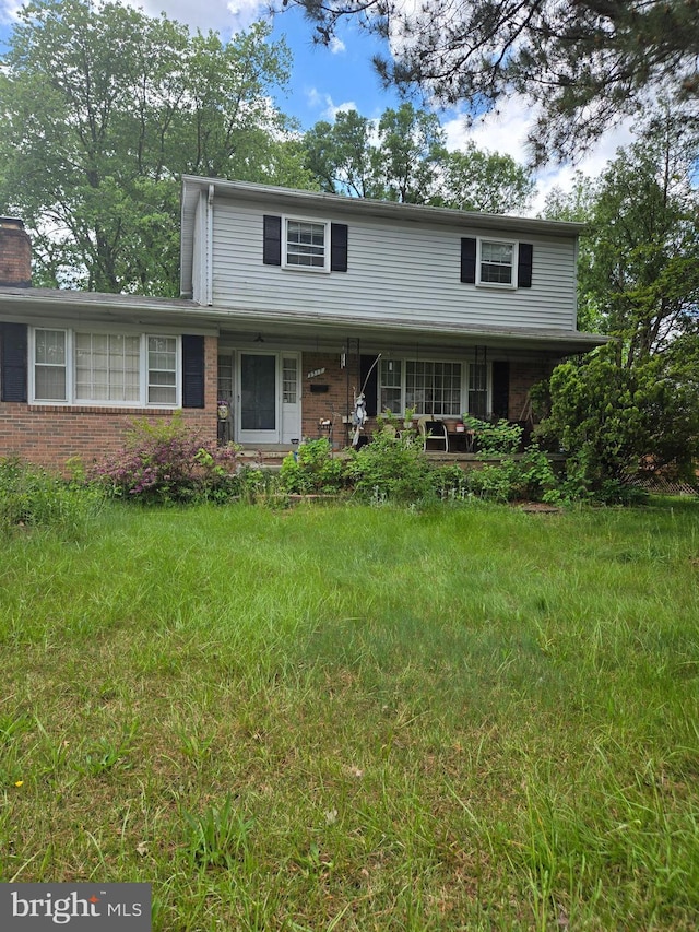 9517 Nordic Dr, Lanham, MD 20706 - traditional-style house with a porch, brick siding, and a chimney
