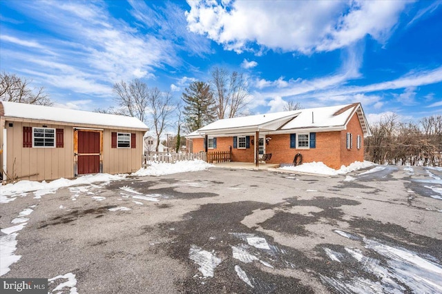 snow covered property with an outbuilding