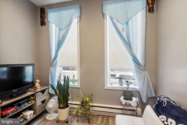 living room with hardwood / wood-style flooring and a baseboard heating unit