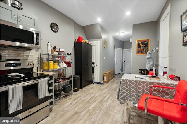 kitchen featuring appliances with stainless steel finishes, backsplash, and light hardwood / wood-style floors