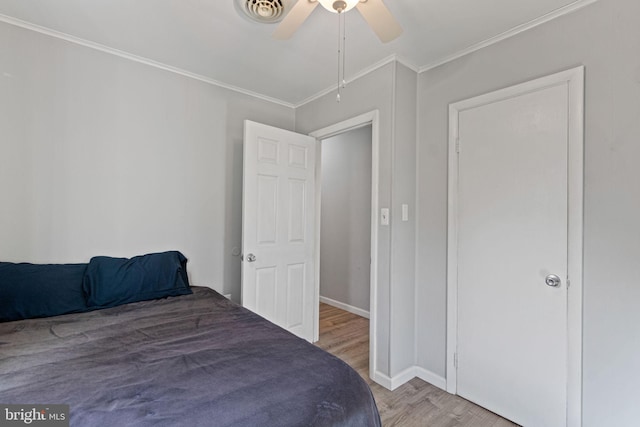 bedroom featuring light hardwood / wood-style flooring, ceiling fan, and crown molding