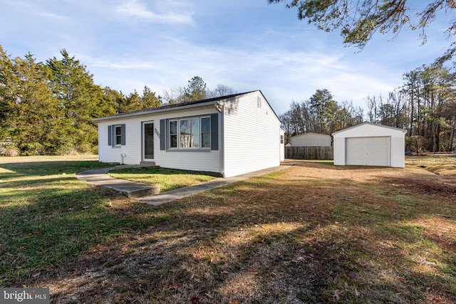 view of front facade featuring an outdoor structure, a front yard, and a garage