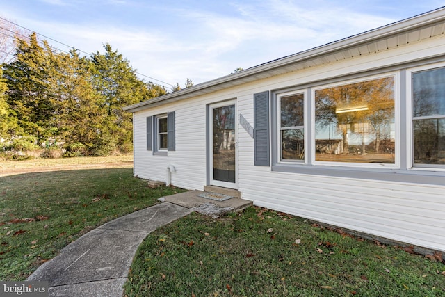 view of exterior entry featuring a lawn