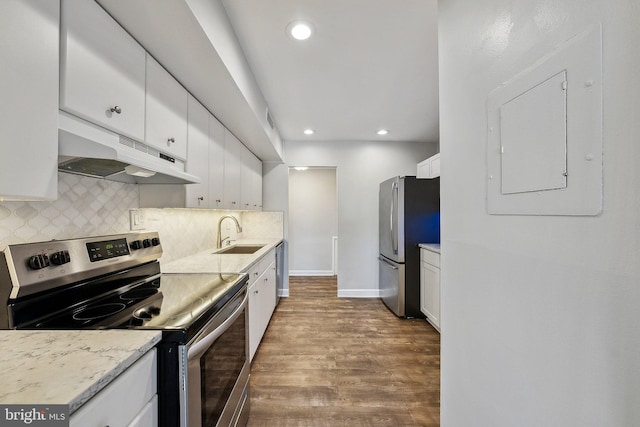 kitchen featuring appliances with stainless steel finishes, hardwood / wood-style flooring, sink, white cabinetry, and tasteful backsplash