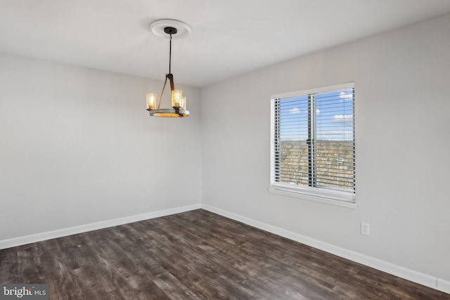 unfurnished room with dark hardwood / wood-style flooring and a notable chandelier