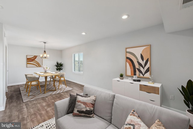 living room featuring a notable chandelier and dark hardwood / wood-style flooring