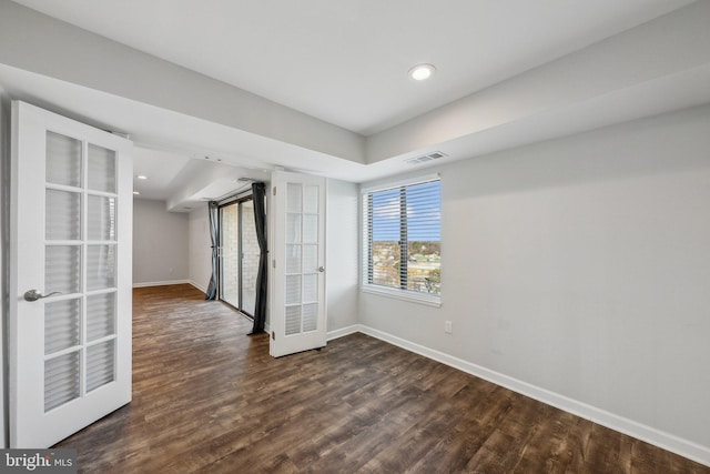 spare room featuring french doors and dark hardwood / wood-style floors