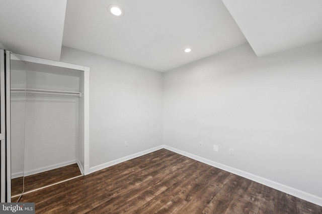 unfurnished bedroom with dark hardwood / wood-style flooring and a closet