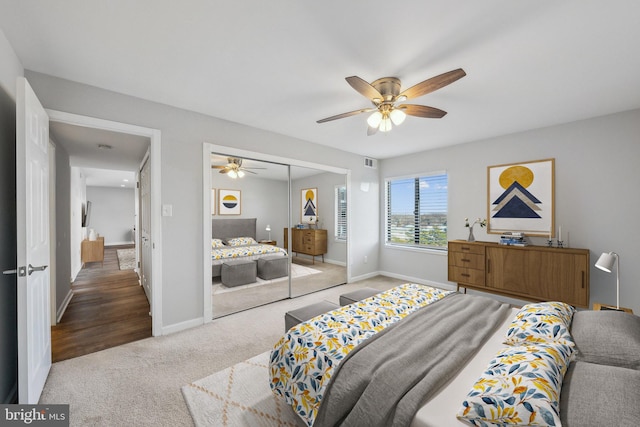 carpeted bedroom featuring ceiling fan and a closet