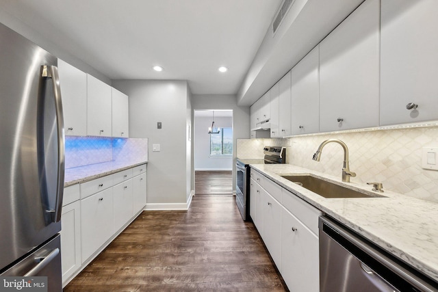 kitchen with sink, white cabinets, light stone counters, backsplash, and appliances with stainless steel finishes