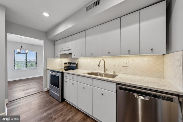 kitchen with hanging light fixtures, stainless steel appliances, backsplash, white cabinetry, and sink