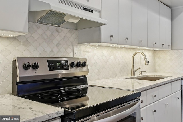 kitchen with sink, stainless steel electric range, white cabinets, and decorative backsplash