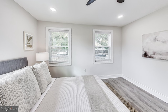 bedroom with multiple windows, hardwood / wood-style flooring, and ceiling fan