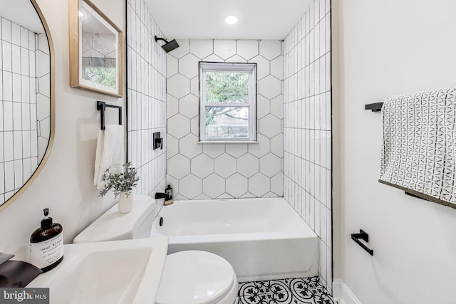 full bathroom with sink, tiled shower / bath, and toilet