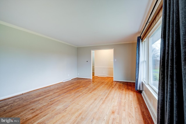 spare room featuring ornamental molding and light hardwood / wood-style flooring