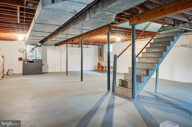 basement featuring water heater, electric panel, and heating unit